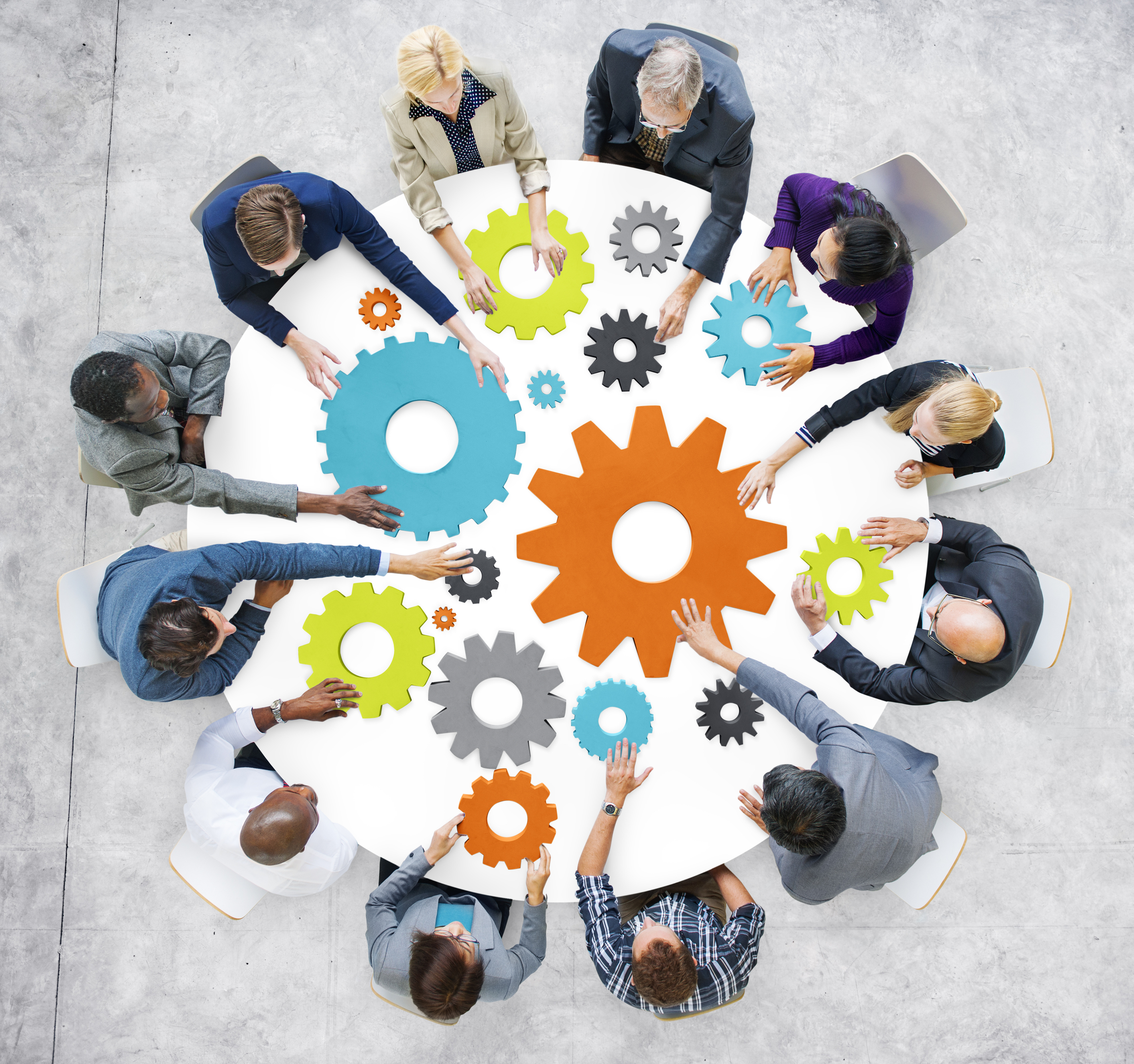 Stock image of people at a table with gear shapes