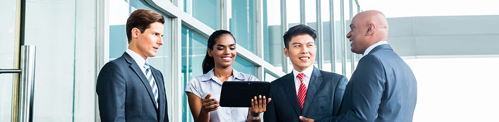 office workers looking at a tablet screen and discussing finances