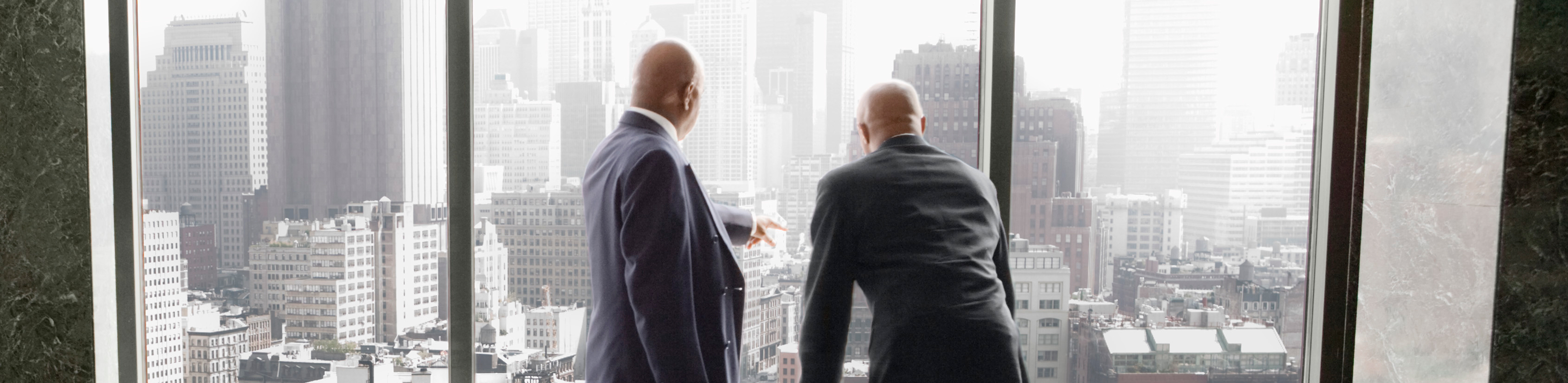 Two businessmen in discussion viewing city