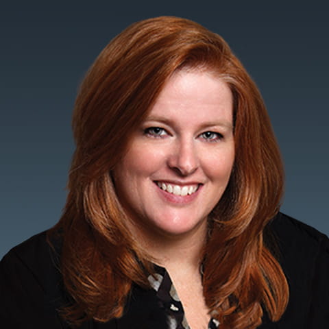 Alison Galer headshot, black suit and red long hair