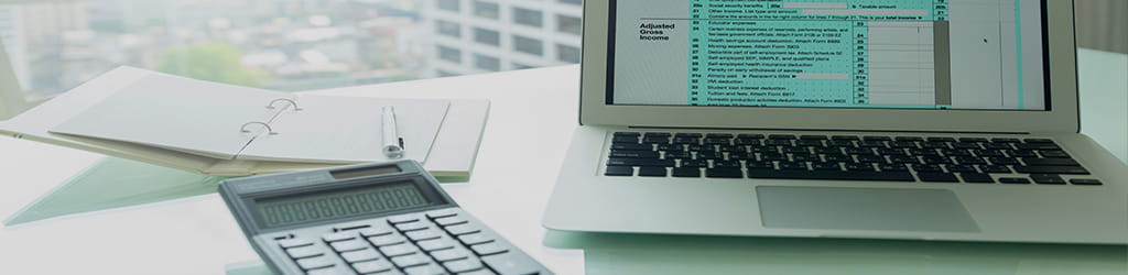 laptop and documents on a work desk