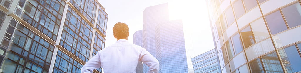 man in front of commercial buildings