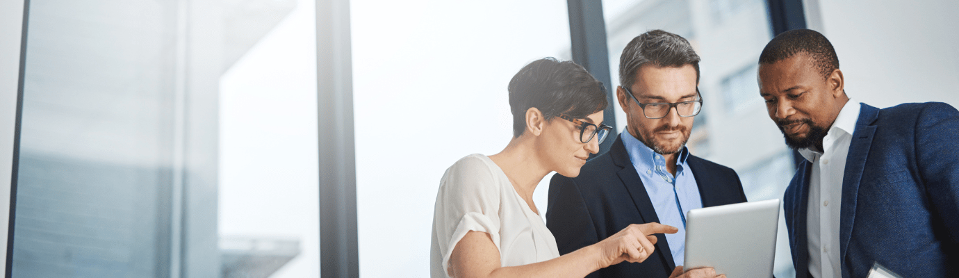three coworkers looking at a tablet