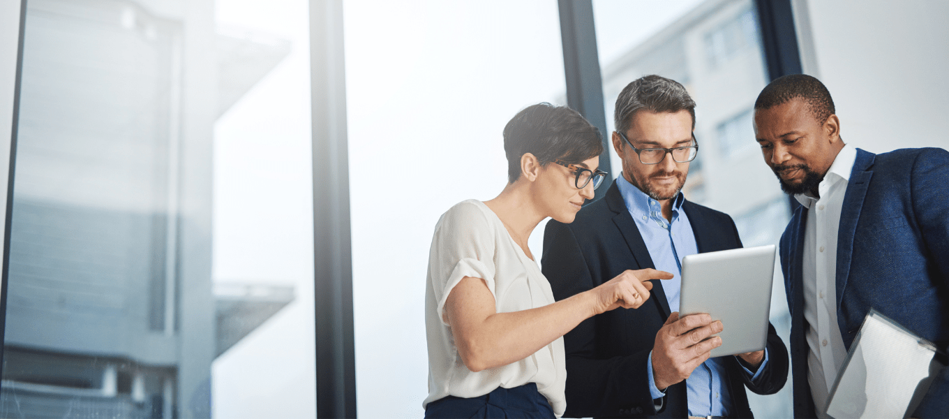 three coworkers looking at a tablet