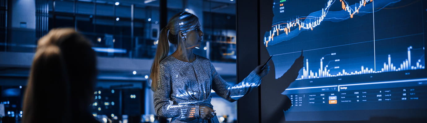a woman giving a presentation using data on a screen