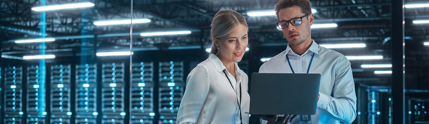 two cyber security professionals looking at a laptop computer