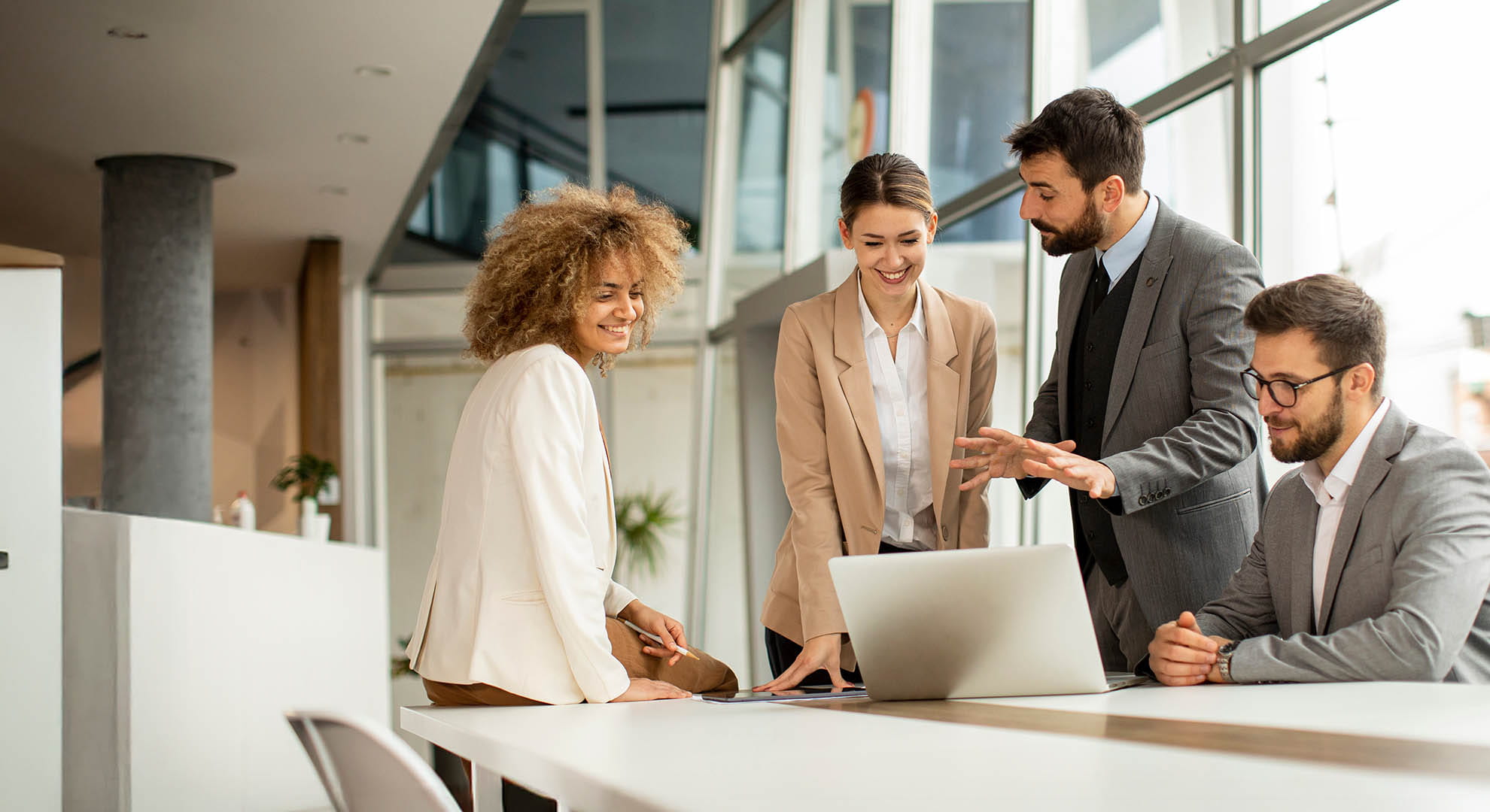 a group of colleagues sharing a laptop computer