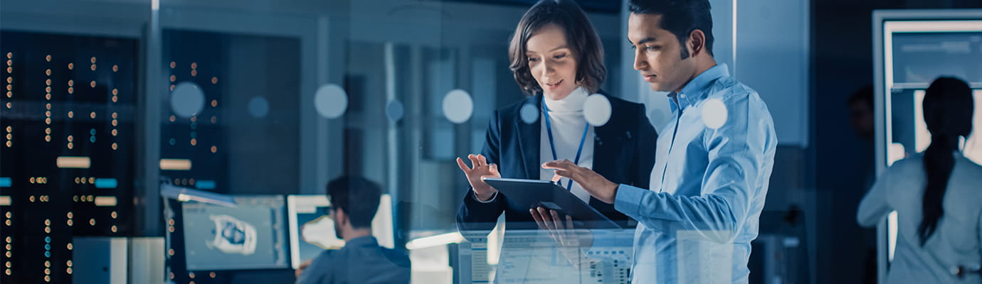 two coworkers looking at data on a tablet