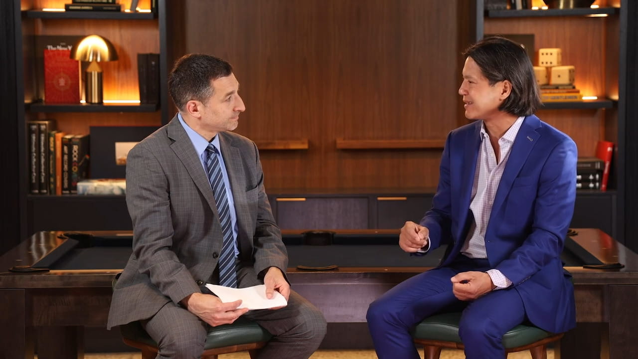 two men in suits having a conversation together in chairs