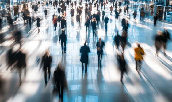 people quickly walking past each other in an office building
