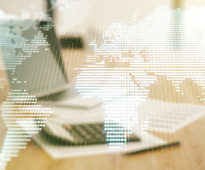 table with calculator and map of world overlay